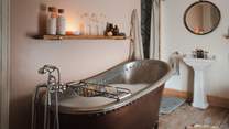 An antique copper bathtub awaits for bubble-topped evening soaks spent in low light