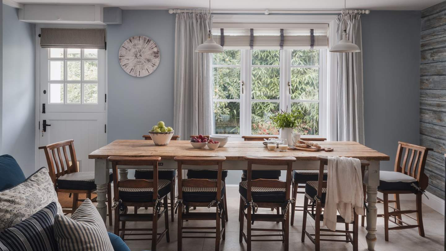 Flowing from the snug, the dining area takes its place beside windows overlooking flourishing garden flora