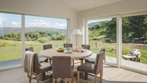 Ready to join guests over full plates and sparkling flutes, a round dining table takes pride of place next to the kitchen, overlooking the garden and the island beyond