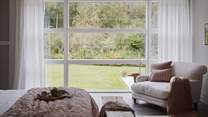 Luxurious linens and throws promise blissful moments of rest, with a colour palette which beautifully complements the verdant vistas from the floor to ceiling windows