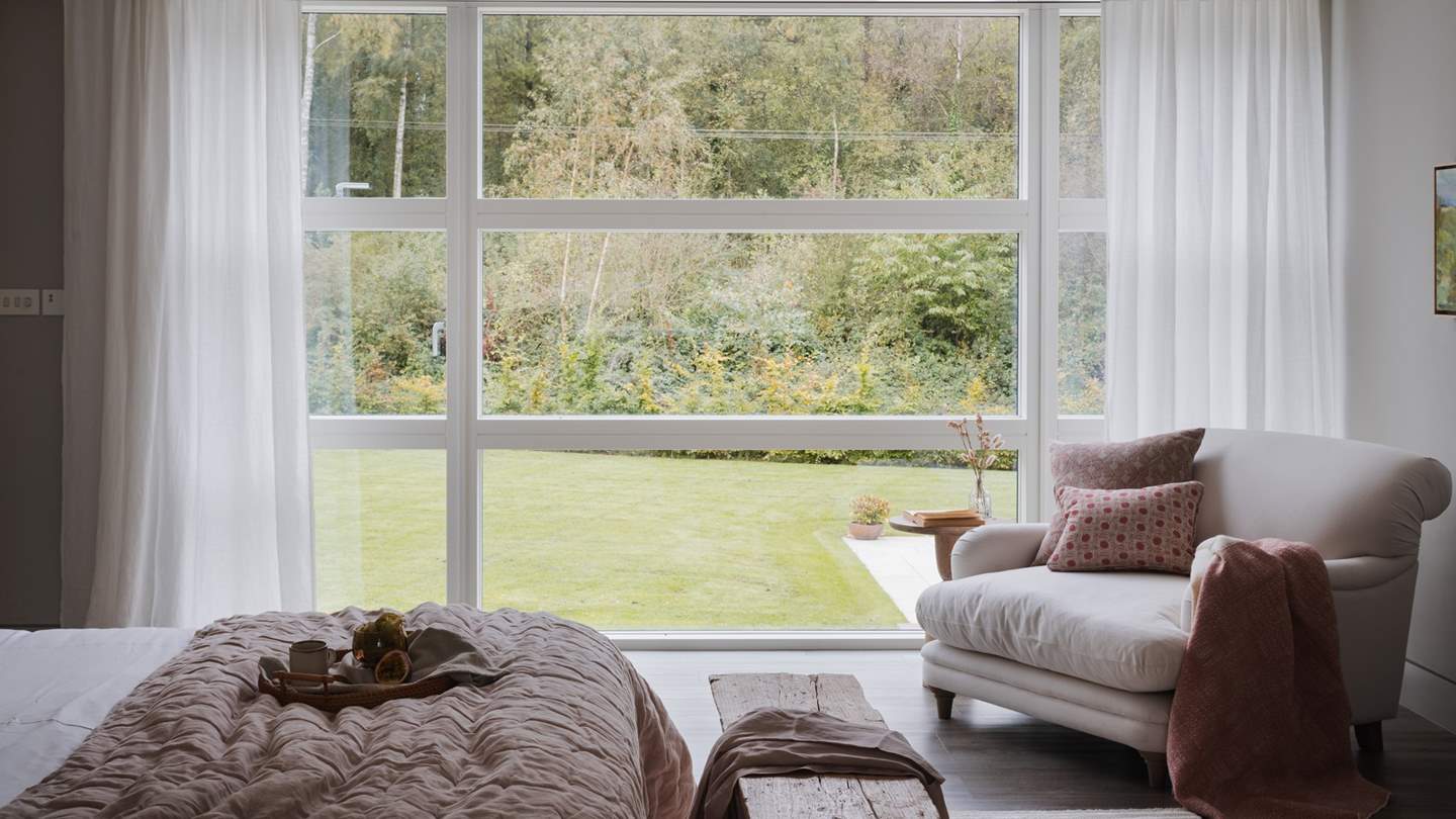 Luxurious linens and throws promise blissful moments of rest, with a colour palette which beautifully complements the verdant vistas from the floor to ceiling windows