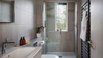 Watch the trees wistfully dance from the sleek shower room