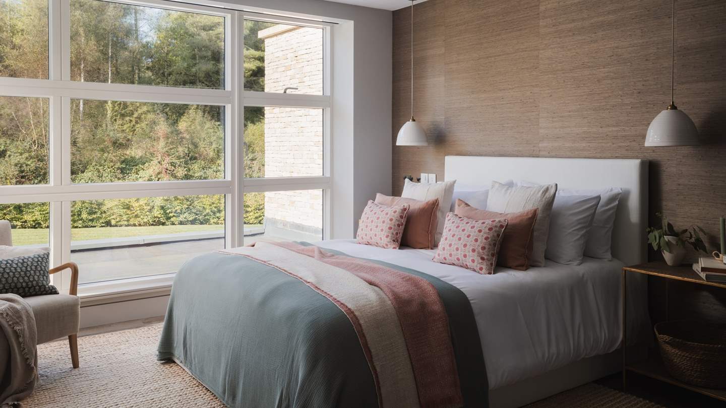 With a textured feature wall in earthy tones, the second bedroom offers a delightful setting to relax at the end of the day