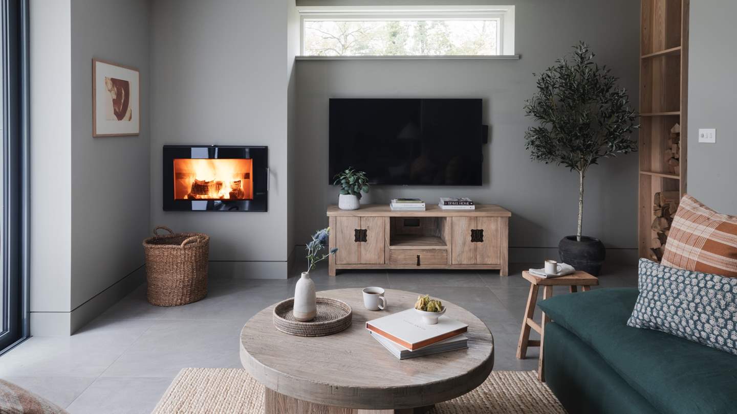 A large Smart TV sits beside the wood burner, boasting a host of streaming services and delights to keep you entertained