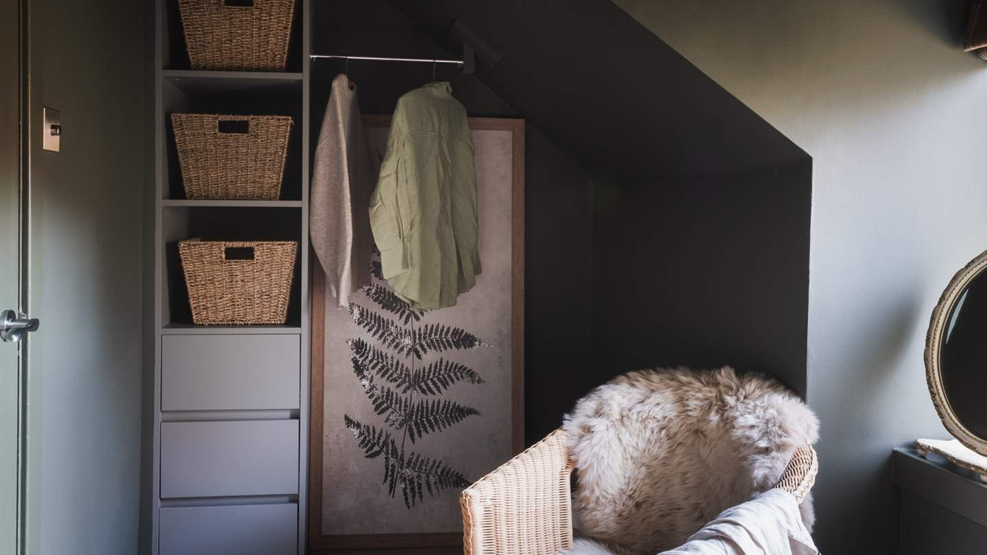 At the other end of the room, a fitted wardrobe and hanging space are set within the eaves, complete with a window-side armchair draped in the softest sheepskin throws