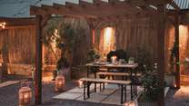Festoon lighting illuminates this calming sanctuary, complete with a wood-fired pizza oven
