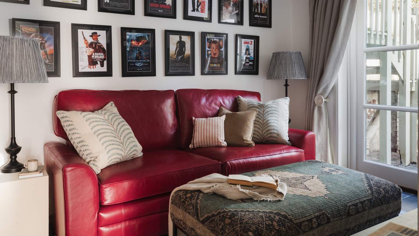 Exuding comfort, it features a vibrant red leather sofa and Persian footstool, as well as a sixty-five-inch Sky TV 
