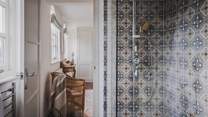 This bedroom is completed with an ensuite bathroom with a walk-in shower with earthy Moroccan tiles