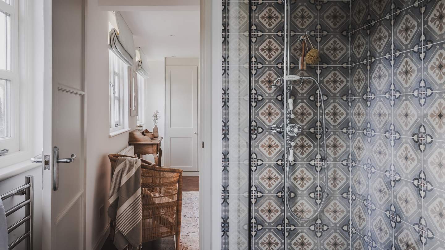 This bedroom is completed with an ensuite bathroom with a walk-in shower with earthy Moroccan tiles