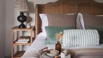 Hugging the bed are two bedside tables, while an elegant dressing table sits beside the window