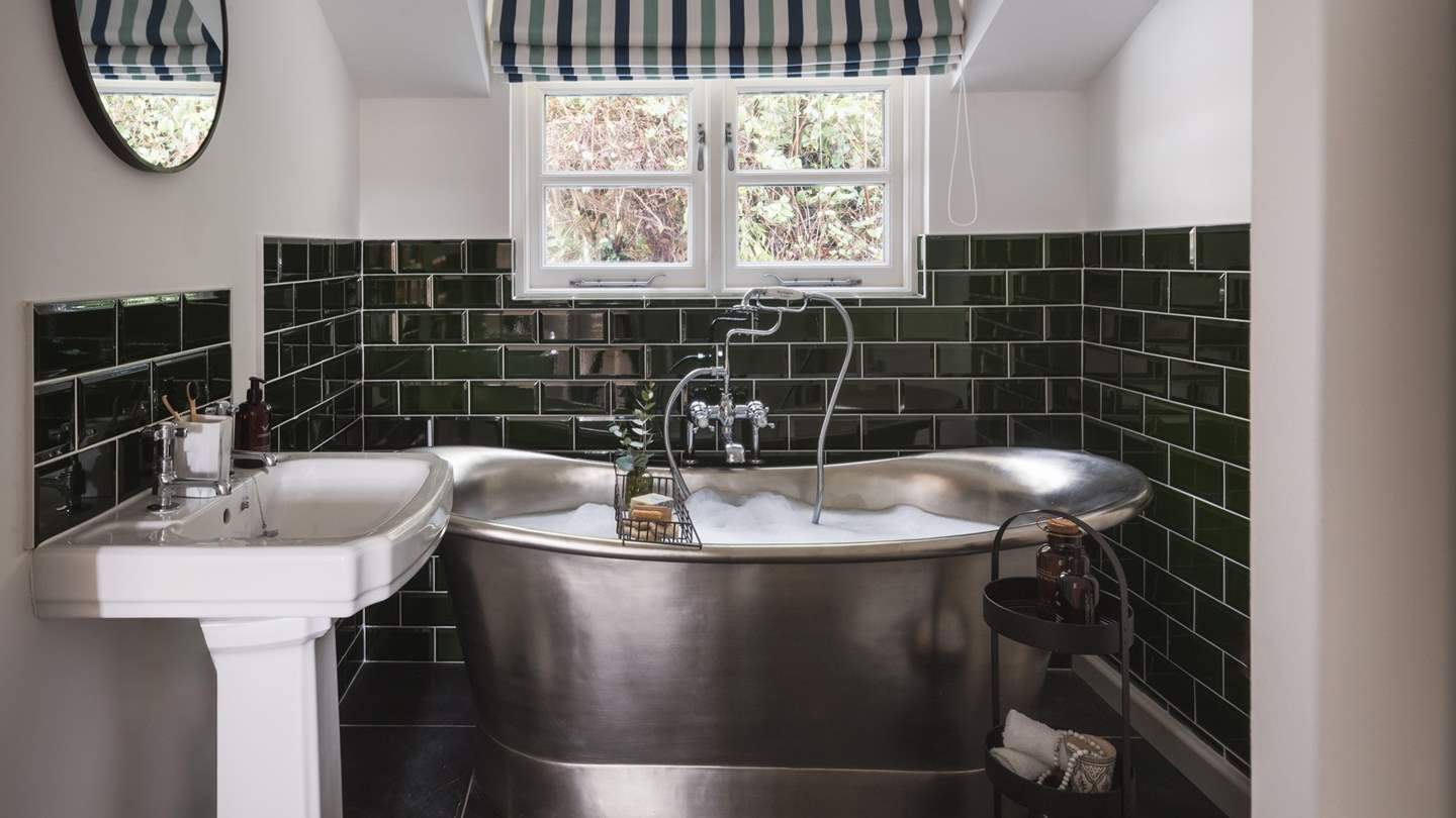 The family bathroom has a heavenly nickel, roll top bath with handheld shower