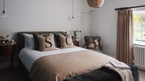 Sumptuously cosy, the fourth bedroom is home to a super king bed adorned in the finest linens