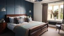 The second bedroom features a mahogany framed super king bed, dressed in sumptuously soft bed linen from Rise and Fall