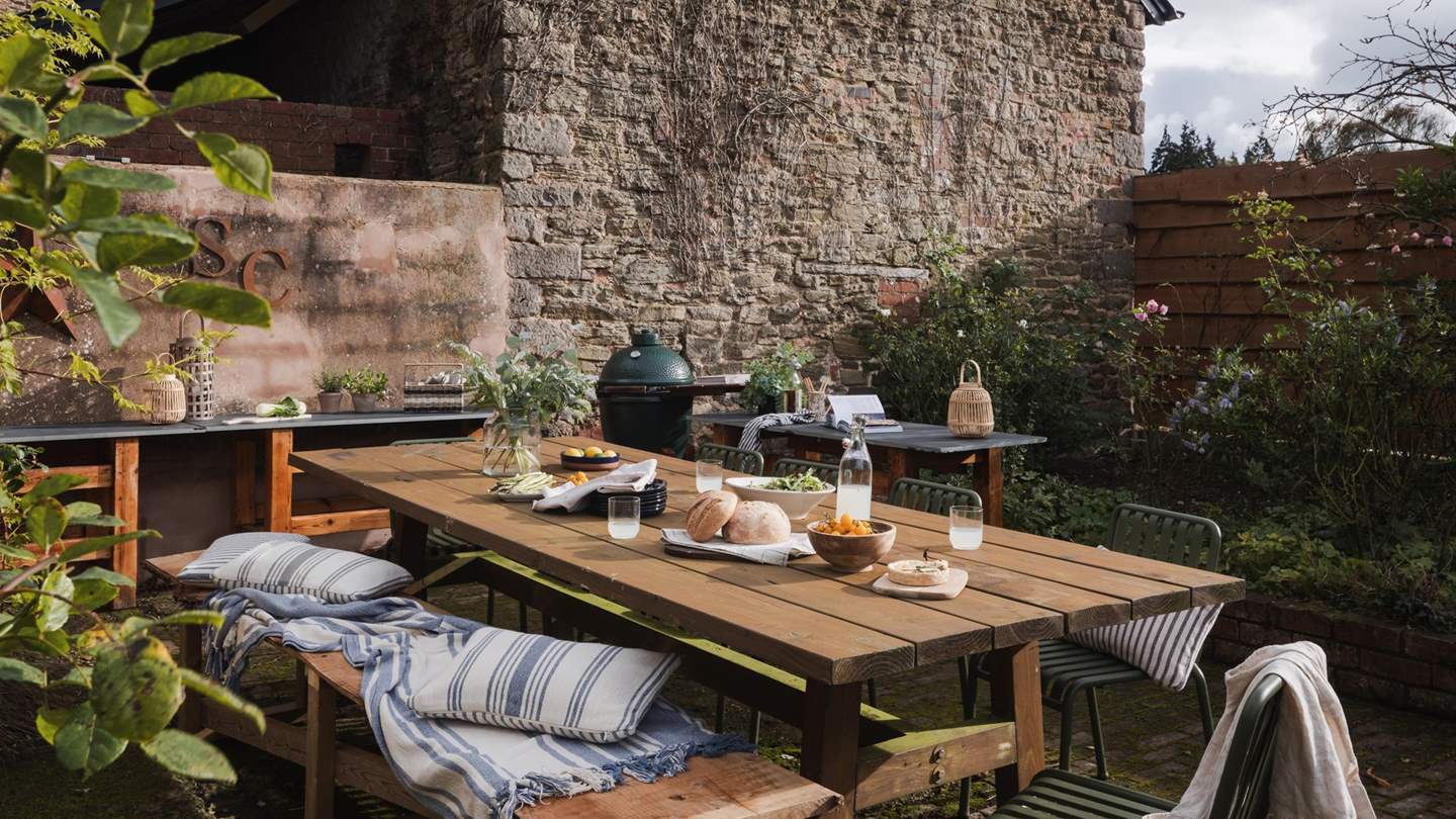 Perfect for gathering together, an outdoor kitchen area near the pool features a Big Green Egg BBQ and a large outdoor dining table and chairs