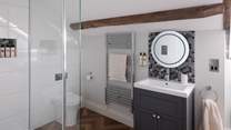 Adjoining the fifth bedroom is an ensuite with a walk-in waterfall shower