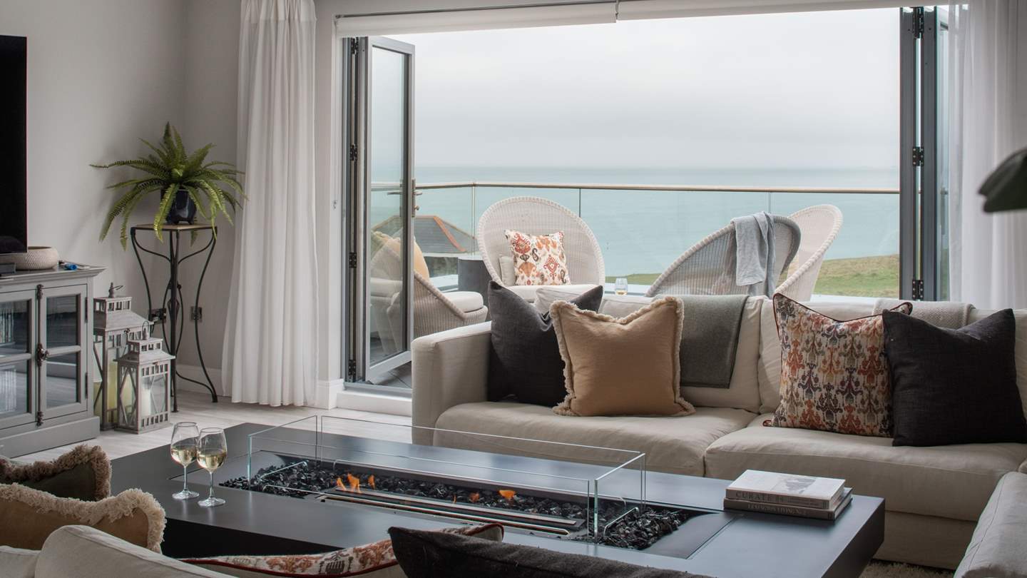 A picture of curated perfection, the heart of the home stars an open-plan lounge, kitchen and dining area with dreamy views over Fistral and Newquay Bay