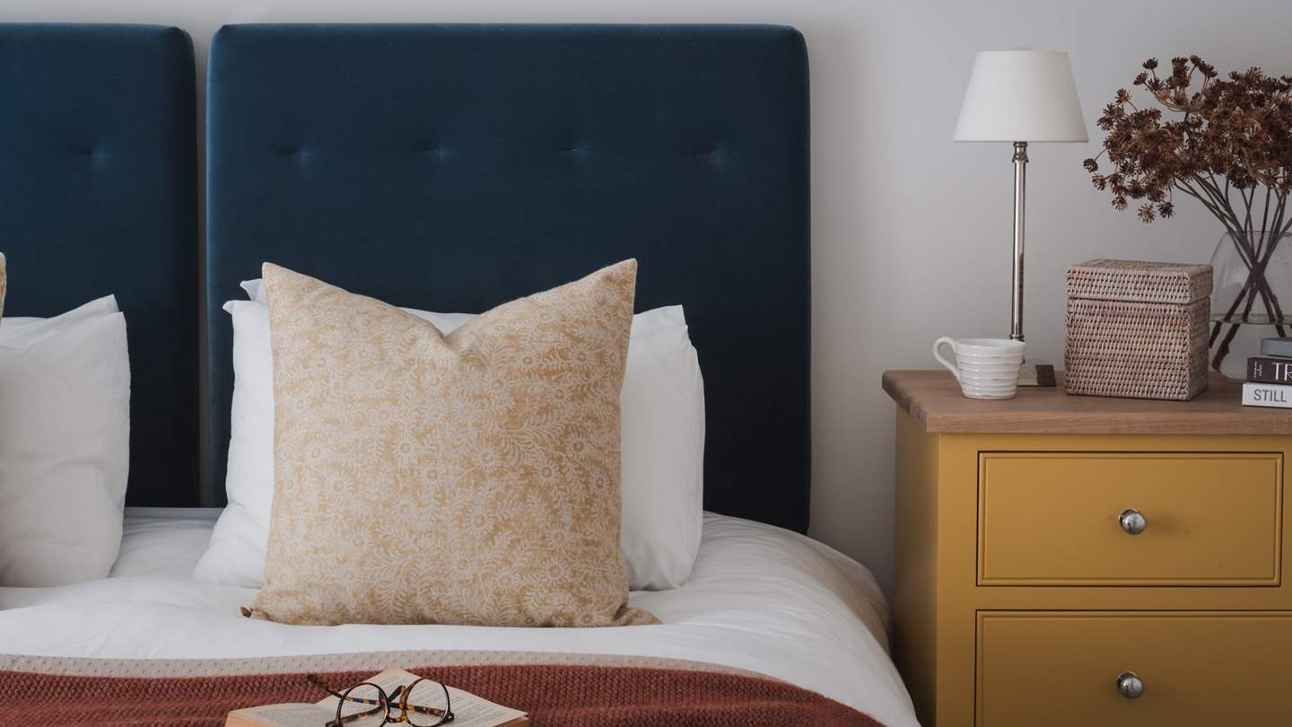 Providing space for storing treasures are a chest of drawers, wardrobe and twin bedside tables