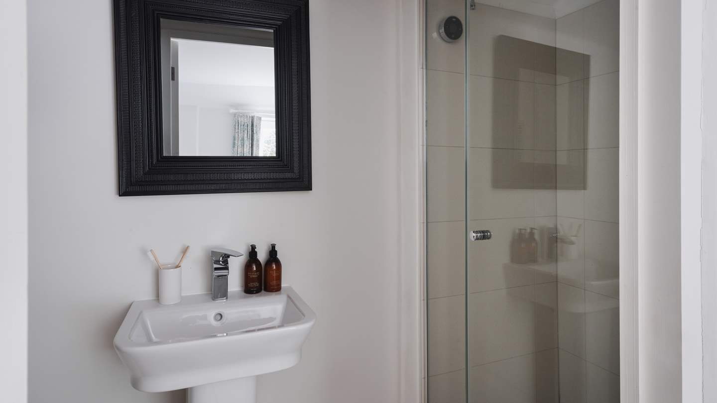 This bedroom enjoys its own ensuite bathroom with a shower