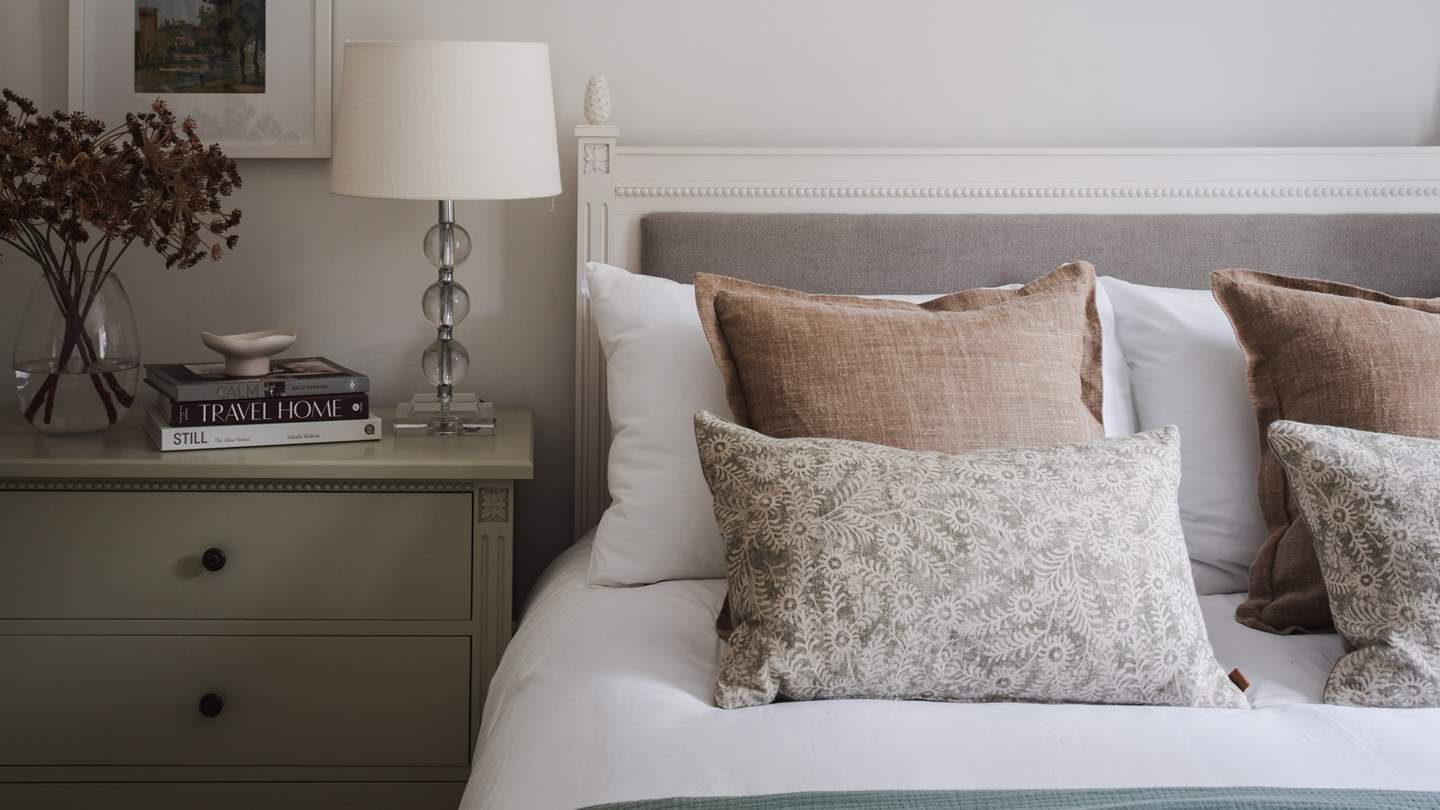 Setting soft lighting are dimmer lights and twin lamps atop bedside tables, while affording natural light and direct access to the private garden 