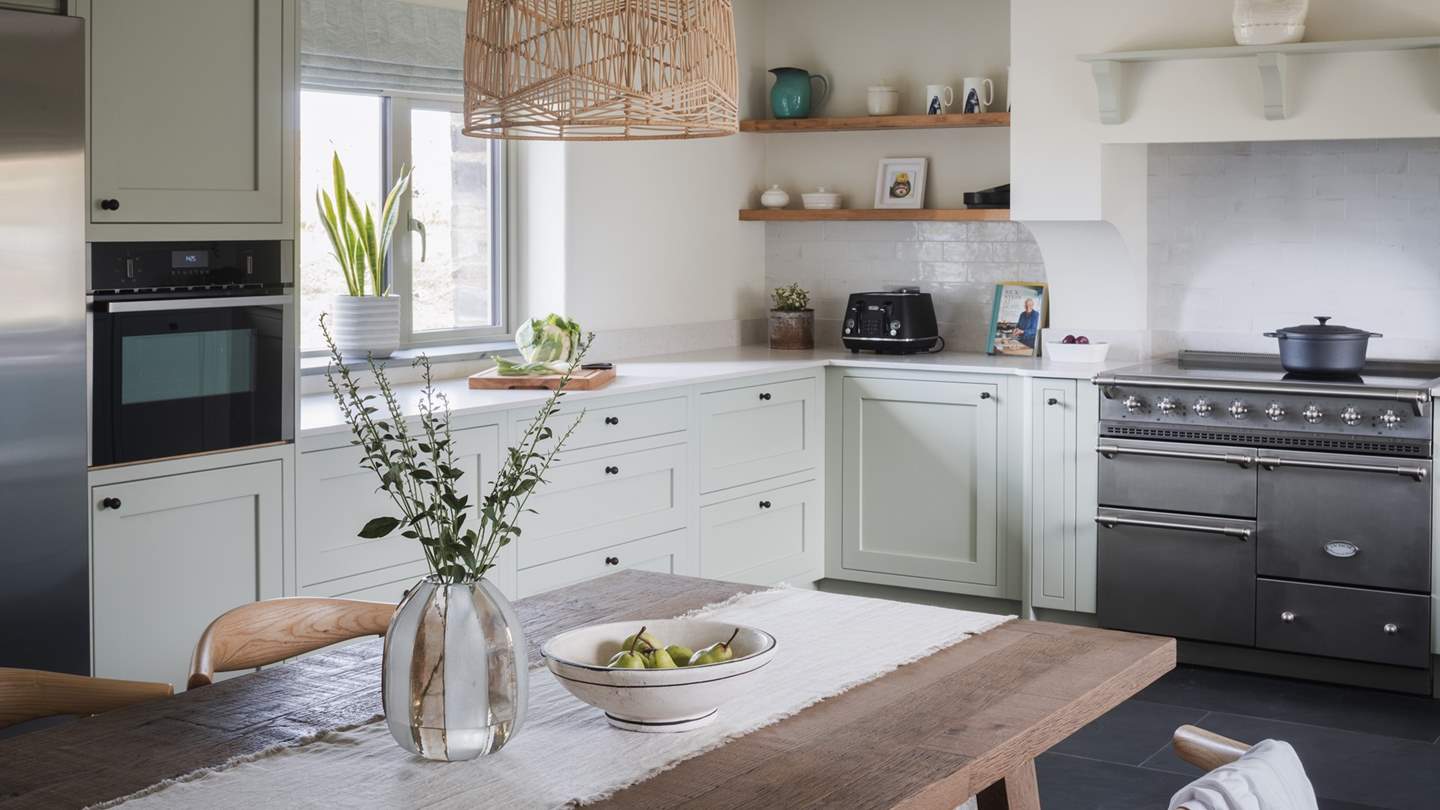 A beautiful space for gathering over handcrafted fare, a wood dining table takes pride of place in the centre of the room, paired by six chairs and softly-lit by statement hanging lamps
