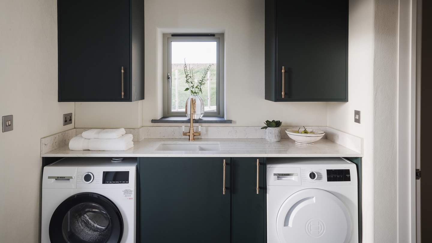 The utility area featuring marble-topped workspaces and striking green units with bronze inflections