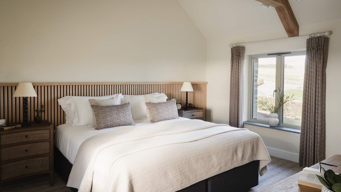 The second bedroom also rests on the first floor and enjoys high ceilings, beautiful, exposed beams, and calming colours 