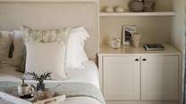 Enjoying a neutral palette, it has two alcoves with integrated open shelves and twin bedside tables
