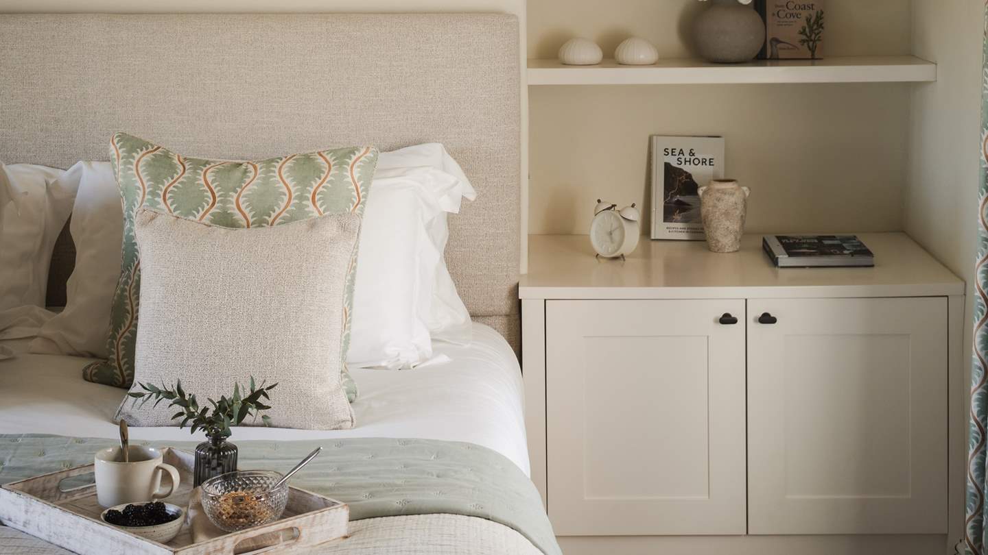 Enjoying a neutral palette, it has two alcoves with integrated open shelves and twin bedside tables
