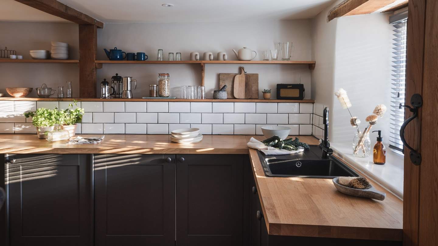 Within bespoke charcoal grey cabinets you’ll find all you should need to prepare meals for two