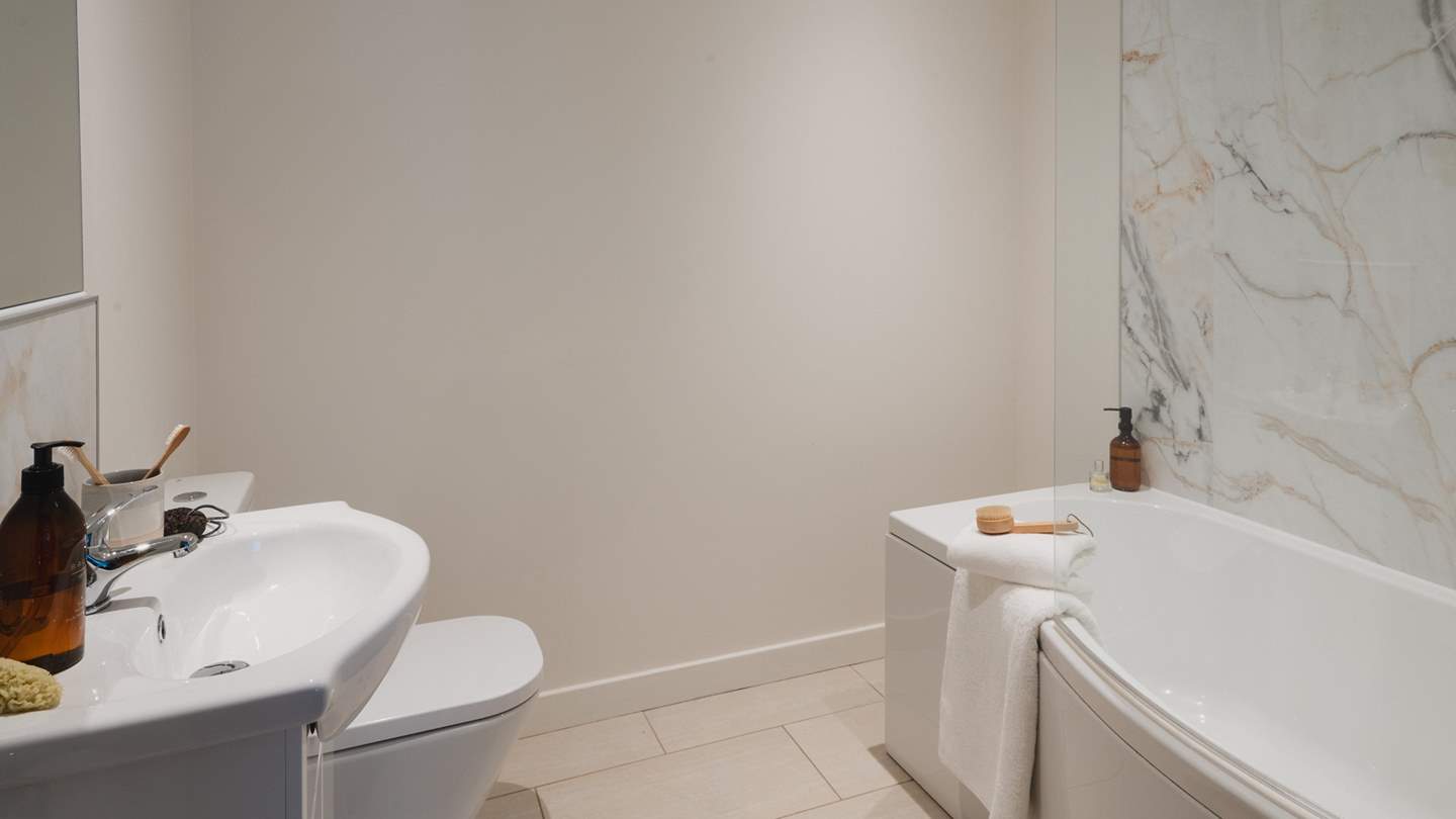 The delightful en-suite includes a bath with an overhead shower