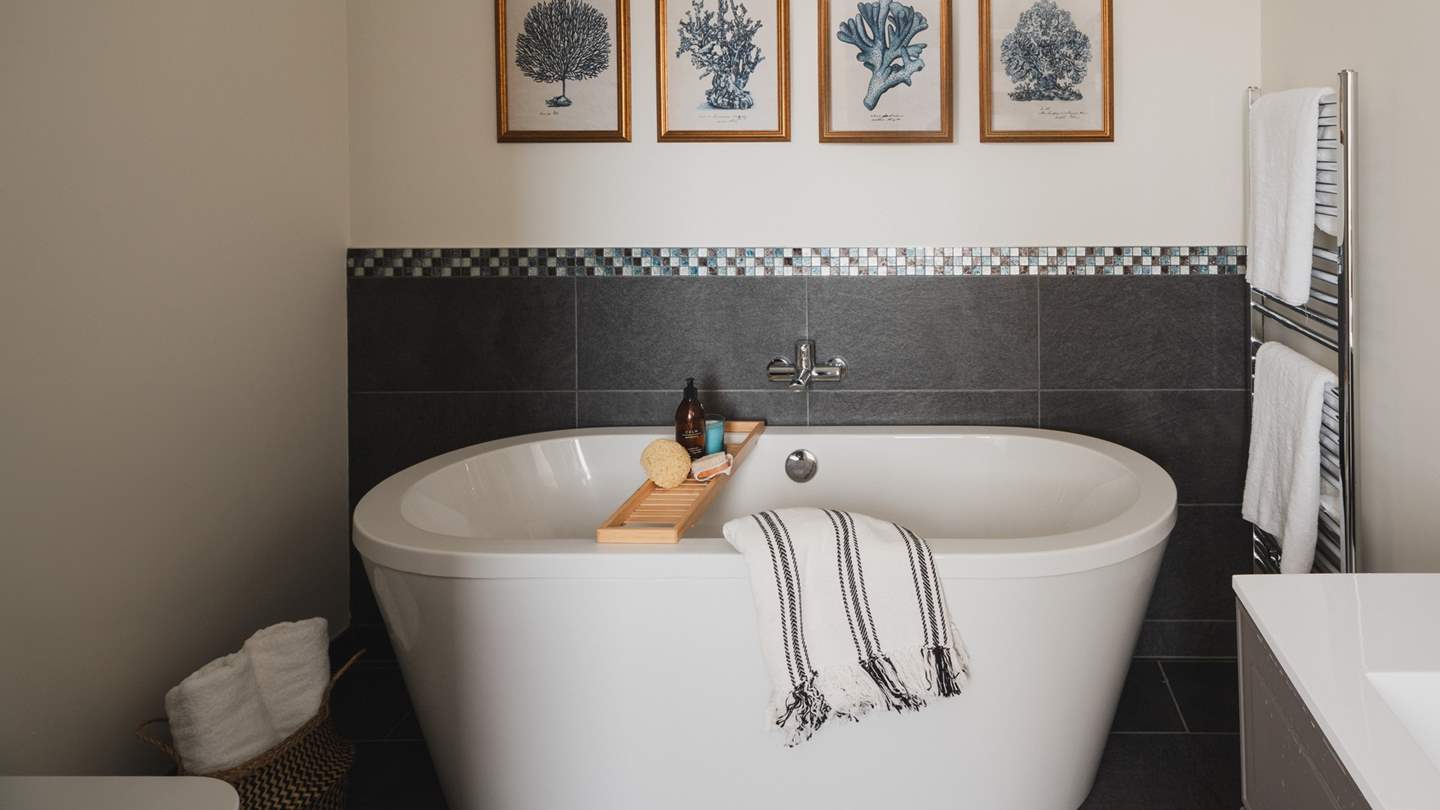 Adjacent is the en suite bathroom, complete with an oval shaped bathtub and a separate enclosed shower