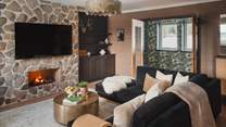 A hand-crafted rustic stone fireplace rests in the centre of the space