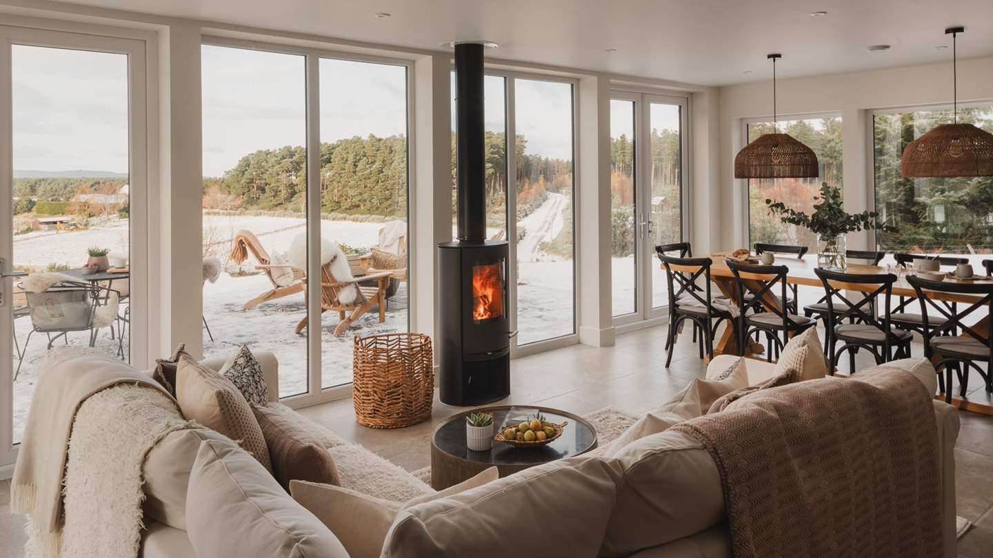 A charming wood burning stove draws your eye to the views beyond Birkenbaud in the main open-plan living space 