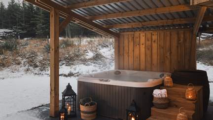 Unwind in the balmy waters of the electric hot tub with a glass in hand