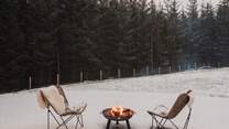 Toast marshmallows and sip whisky beside the enchanting pine forest