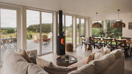 A charming wood burning stove draws your eye to the views beyond Birkenbaud in the main open-plan living space 