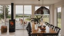 In the main living, kitchen and dining space, floor-to-ceiling glass windows and doors accentuate the uninterrupted countryside views below
