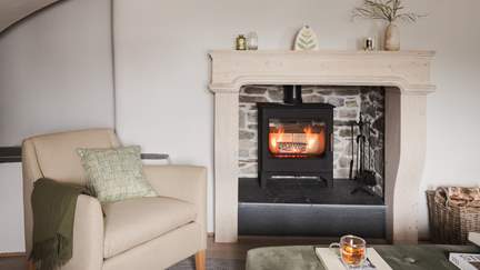 A sanctuary to while away the hours, there is plenty of seating to gather together around the handsome wood burning stove, set in a striking, stone hearth