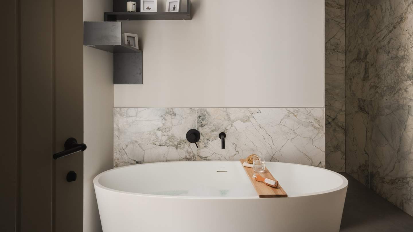 Next door is the pretty family bathroom, an opulent space with a contemporary free-standing bathtub, a spacious walk-in shower and a heated rail