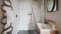 Hidden behind a sliding door is the gorgeous en suite bathroom, with a shower and a heated rail