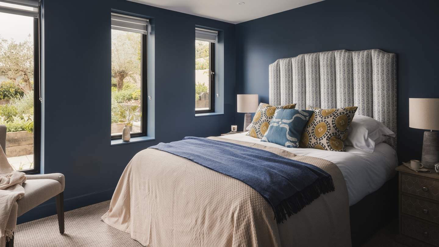 Soothing blues reign in the third bedroom, where a king-sized bed with a fluted headboard awaits for lingering lie-ins