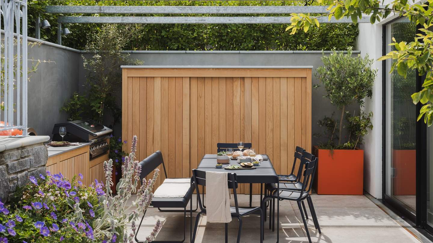 Adjoining the indoor and outdoor spaces with glass sliding doors, the exquisite Mediterranean-esque outdoor kitchen 