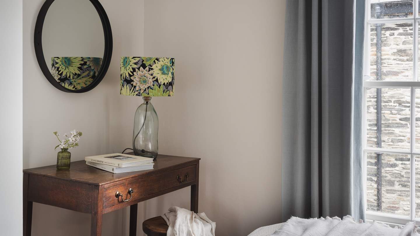 Built-in wardrobes and an antique dressing table offer generous storage for treasures and complement the rich wood and forest tones of this space