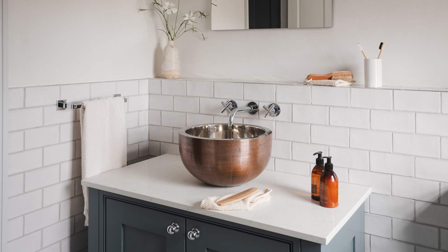 Featuring a beautiful copper basin and a walk-in shower for self-care rituals