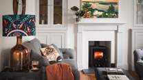 Nestled within an alcove fireplace, a wood burning stove promises soothing moments in the cosy seasons
