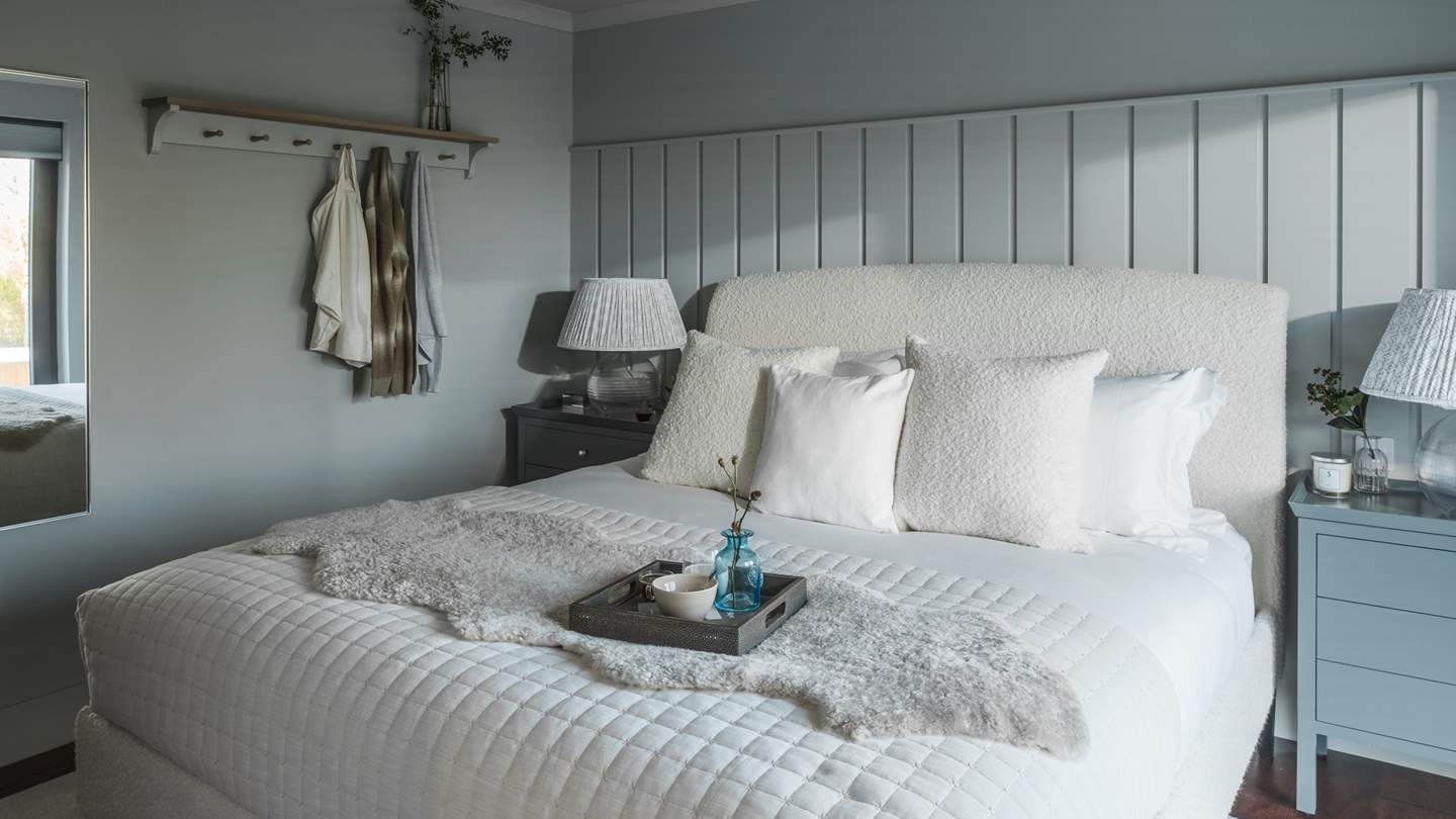 Savour the dreamiest slumbers in the boucle super king size bed, dressed in cosy quilts, throws and cushions in porcelain tones