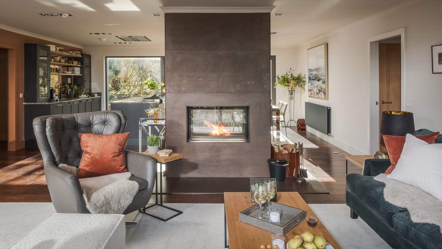 At the heart of the room is a double-sided glass front wood burning stove, promising cosiness in abundance in the cooler months