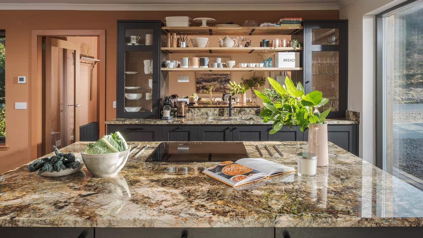 At the far side of the space, uncover a shaker style kitchen in rich tones