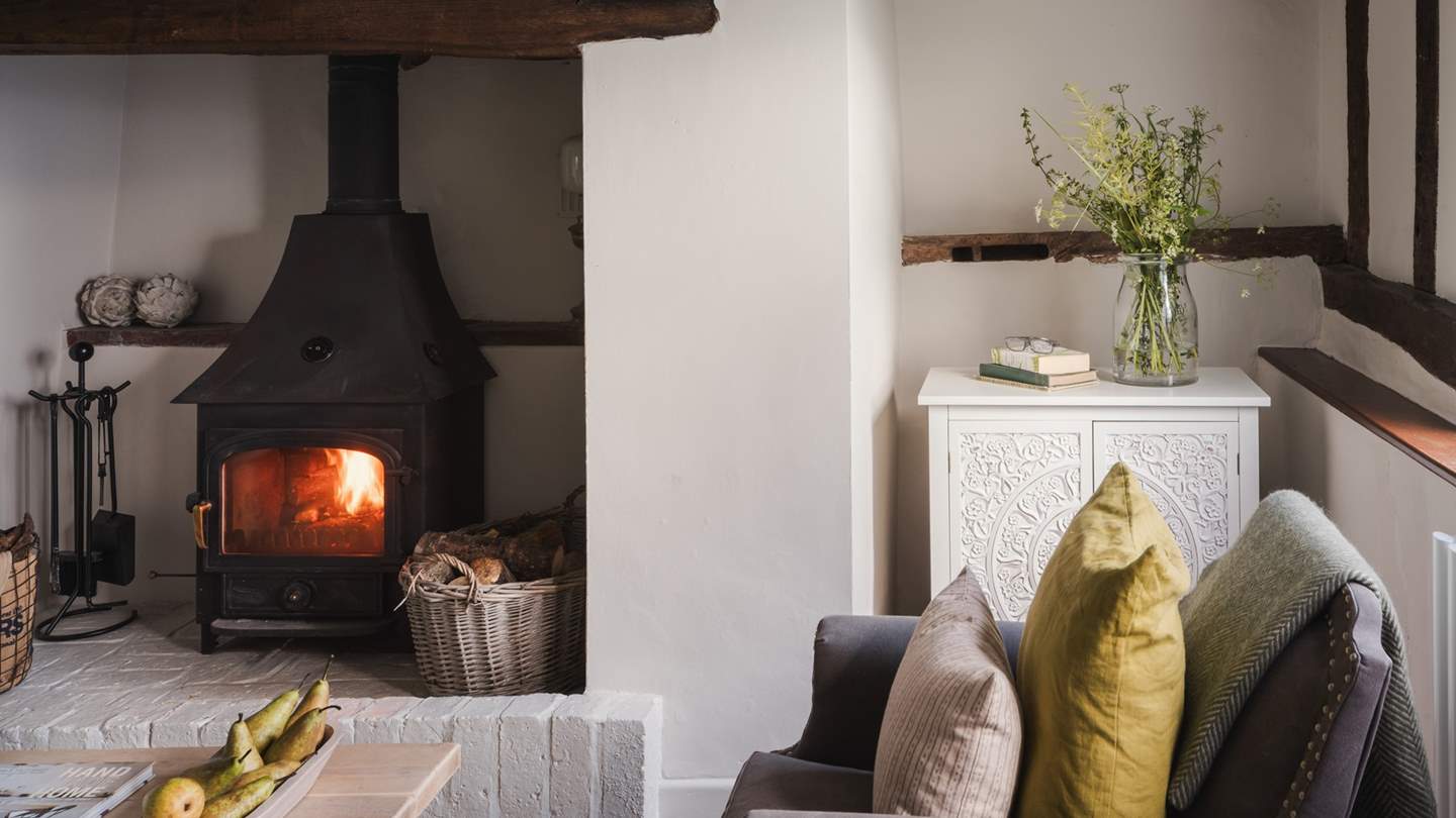 A Clearview woodburning stove takes centre stage, cocooned within a grand fireplace with a rustic hearth