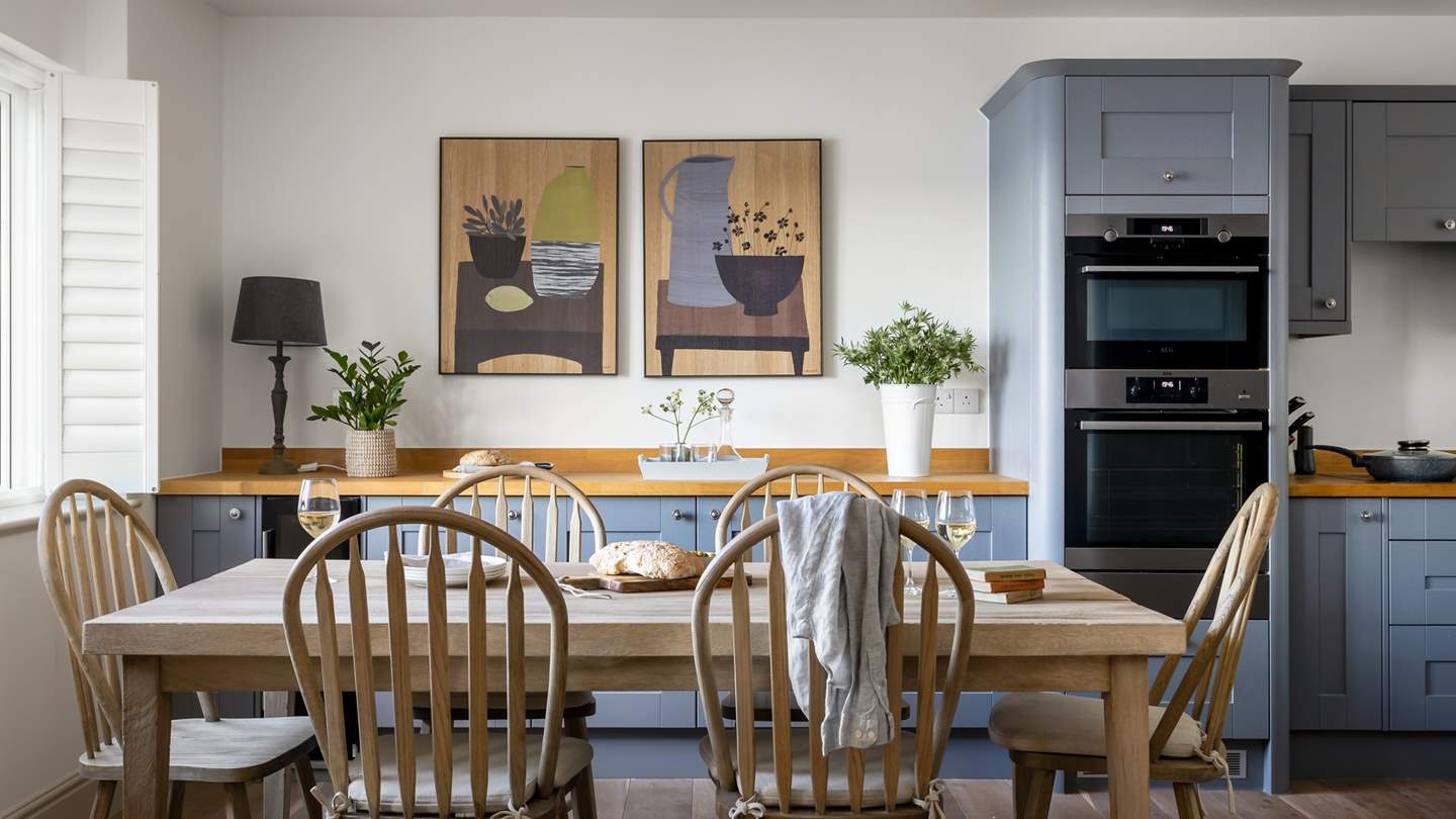 In the centre of the kitchen and dining space, a family-sized dining table with chairs for six beckons for breakfasts and banquets 